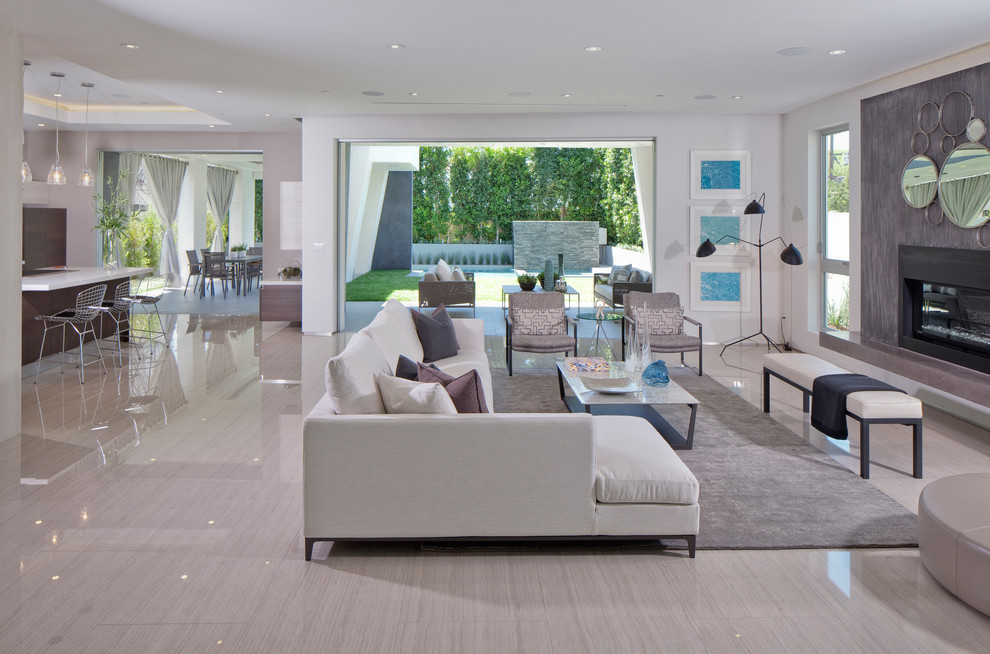 Large contemporary open concept living room in Los Angeles with white walls, porcelain floors, a standard fireplace and a metal fireplace surround.