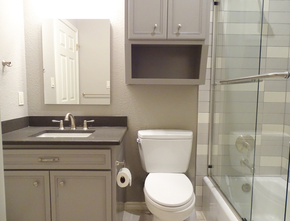 Photo of a small transitional kids bathroom in Austin with shaker cabinets, grey cabinets, an alcove tub, a shower/bathtub combo, a one-piece toilet, gray tile, ceramic tile, grey walls, ceramic floors, a drop-in sink and engineered quartz benchtops.