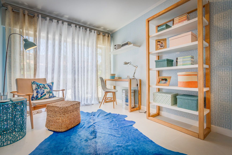Photo of a beach style craft room in Other with blue walls and a freestanding desk.