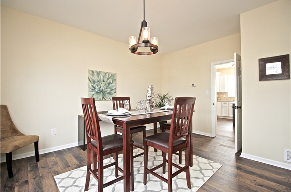 Small traditional separate dining room in Other with beige walls, laminate floors, no fireplace and brown floor.
