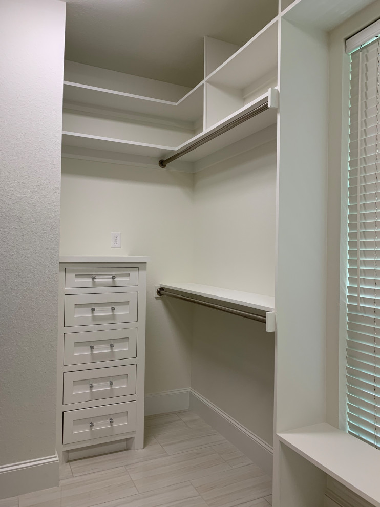 Mid-sized transitional gender-neutral walk-in wardrobe in Dallas with shaker cabinets, white cabinets, porcelain floors and white floor.