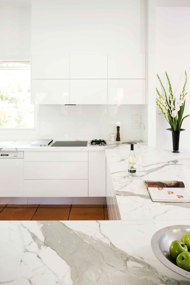 Photo of a mid-sized modern kitchen in Melbourne with marble benchtops, white splashback, porcelain floors and brown floor.