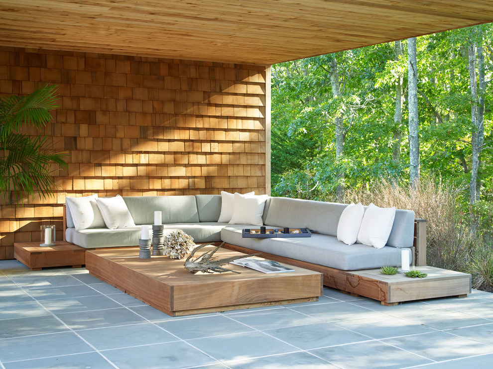 Inspiration for a mid-sized beach style patio in New York with a roof extension.