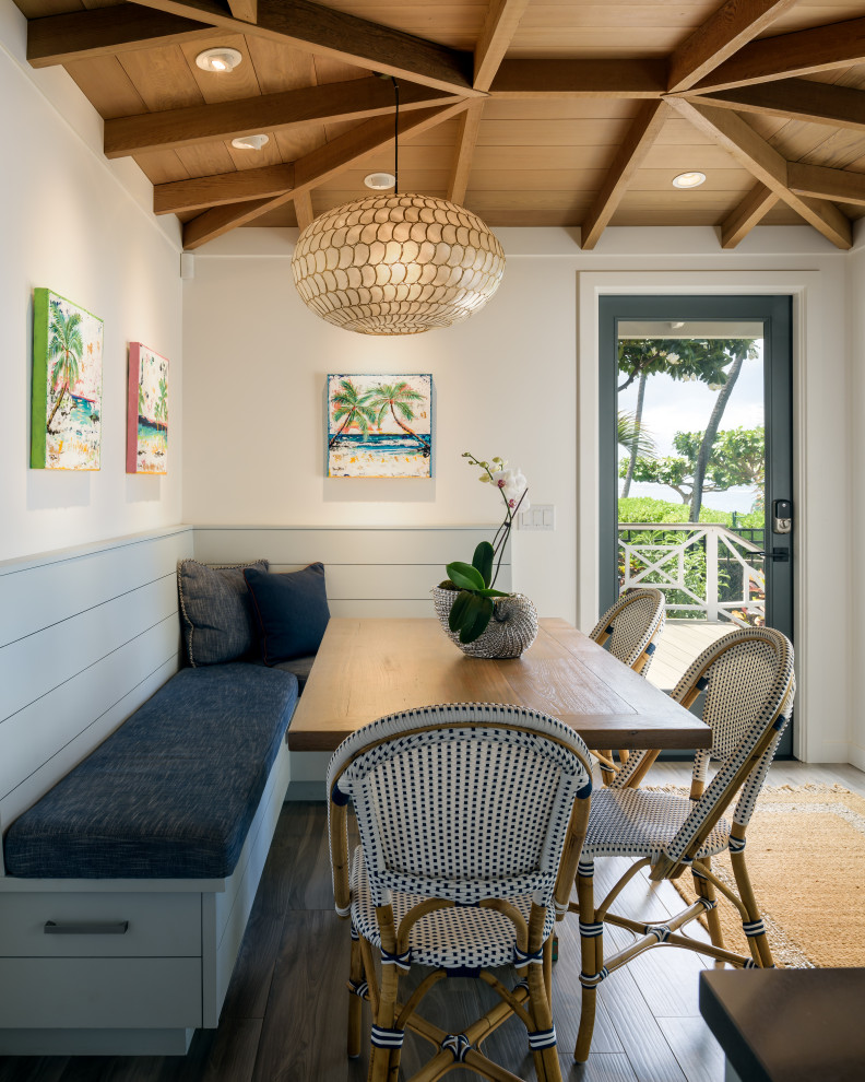 This is an example of a mid-sized beach style dining room in Hawaii with white walls, porcelain floors, grey floor and exposed beam.