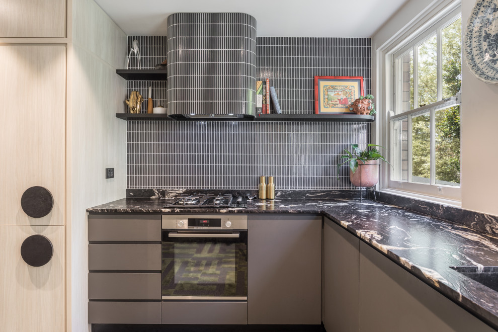 Inspiration for a small contemporary l-shaped kitchen in Sydney with an undermount sink, flat-panel cabinets, quartzite benchtops, grey splashback, panelled appliances, black benchtop, grey cabinets and matchstick tile splashback.