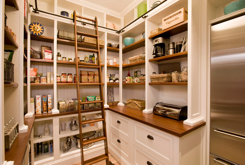 Photo of a beach style kitchen pantry in Boston with white cabinets, wood benchtops, stainless steel appliances and open cabinets.