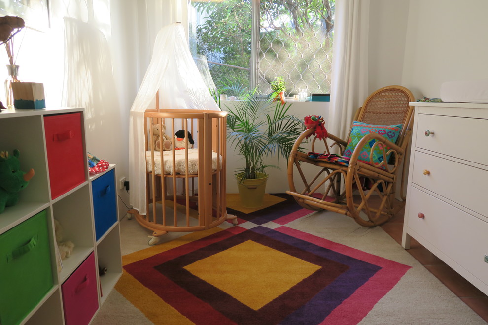 Small eclectic gender-neutral nursery in Brisbane with white walls and carpet.