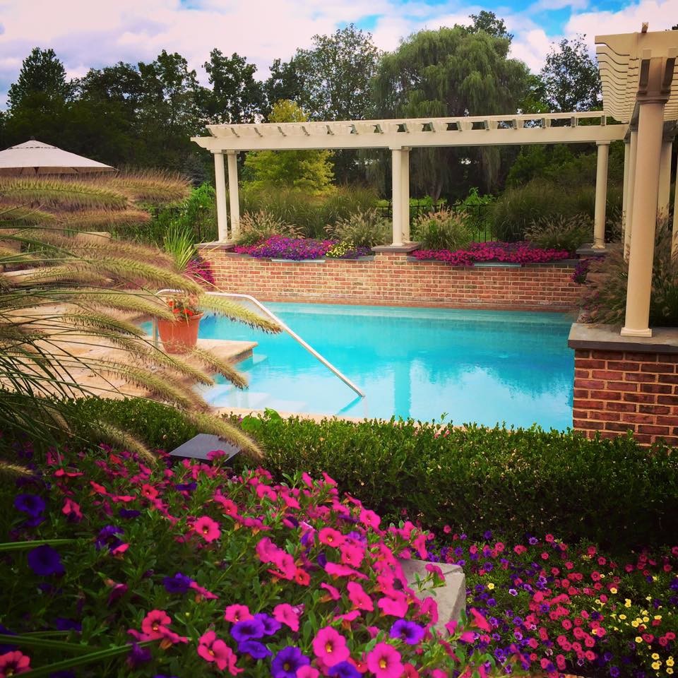 Inspiration for a traditional backyard l-shaped natural pool in Philadelphia with a water feature and natural stone pavers.