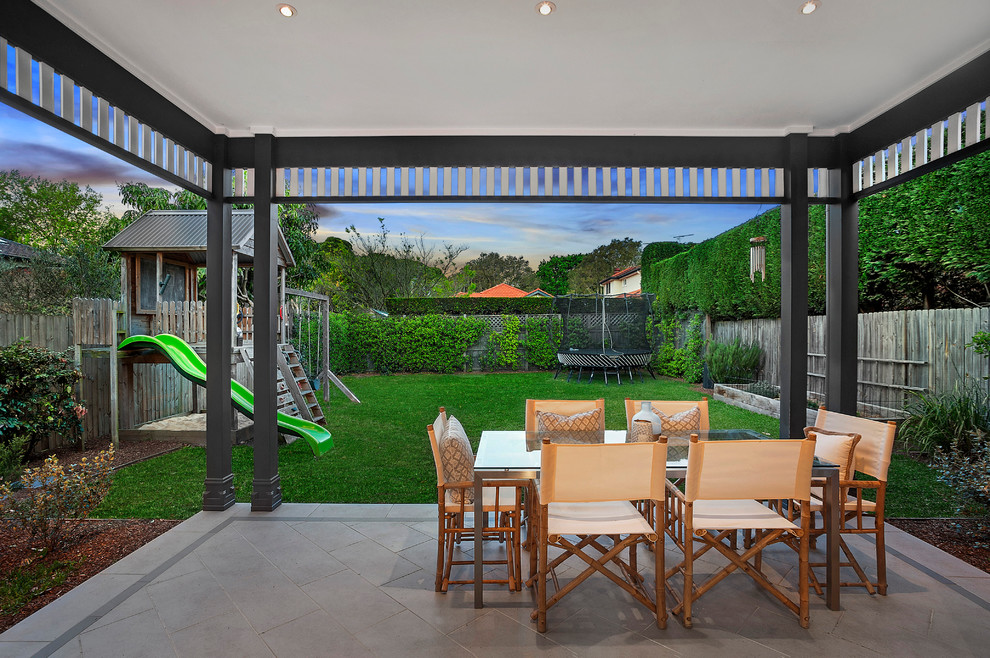 This is an example of a small beach style backyard patio in Sydney with concrete pavers.