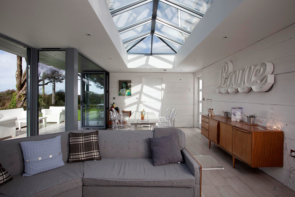 Photo of a small beach style sunroom in Cornwall with light hardwood floors and a skylight.