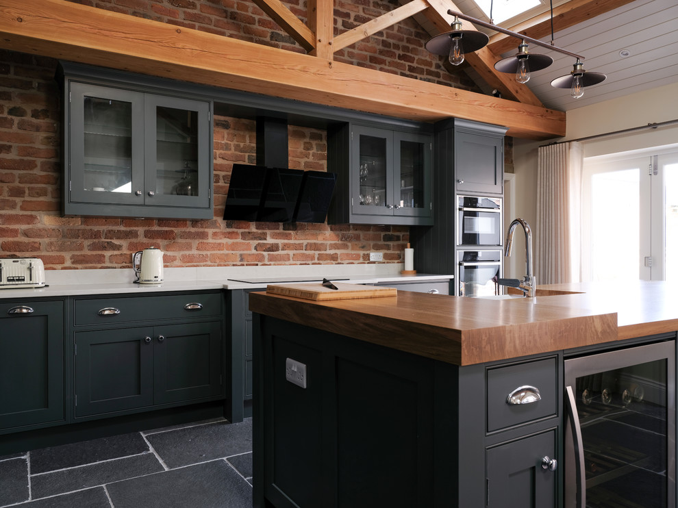 This is an example of a transitional kitchen in Cheshire with quartzite benchtops, slate floors, with island and grey floor.