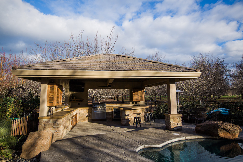 Inspiration for a large modern backyard patio in Other with an outdoor kitchen, a gazebo/cabana and stamped concrete.