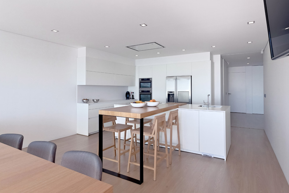 Photo of a large contemporary single-wall open plan kitchen in Other with flat-panel cabinets, white cabinets, white splashback and with island.