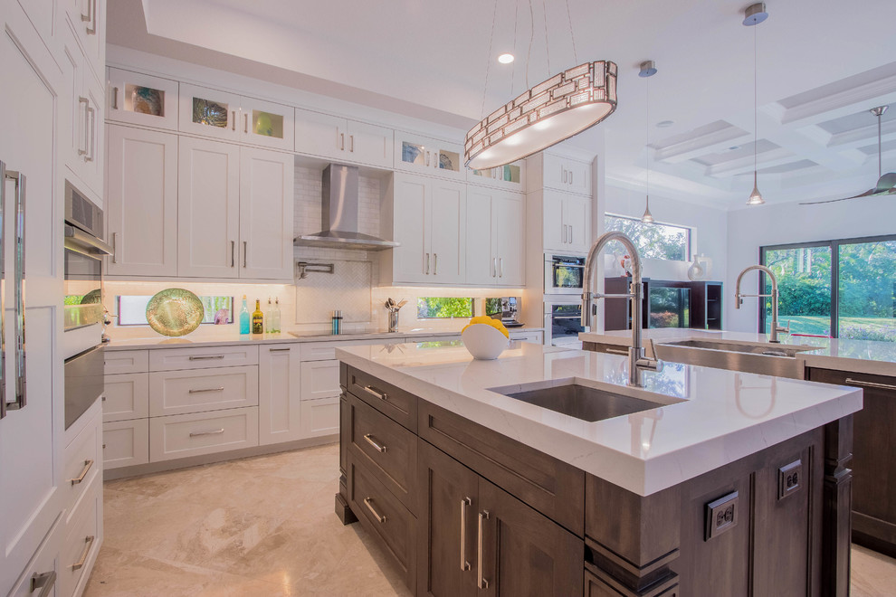 Huge transitional l-shaped porcelain tile and beige floor open concept kitchen photo with a farmhouse sink, shaker cabinets, white cabinets, quartz countertops, white backsplash, porcelain backsplash, stainless steel appliances and two islands