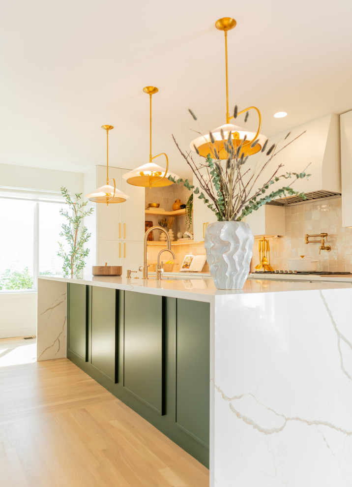 Large classic single-wall kitchen/diner in DC Metro with a submerged sink, shaker cabinets, green cabinets, engineered stone countertops, beige splashback, ceramic splashback, stainless steel appliances, light hardwood flooring, an island, beige floors and white worktops.