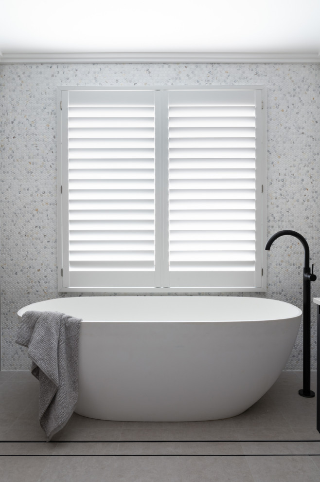 Immagine di una stanza da bagno padronale contemporanea con ante nere, vasca freestanding, top bianco, due lavabi e mobile bagno sospeso