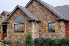 Mid-sized mountain style brown one-story stone gable roof photo