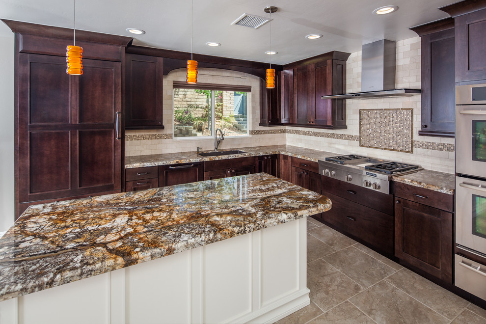 Inspiration for a mid-sized arts and crafts l-shaped eat-in kitchen in San Diego with an undermount sink, shaker cabinets, dark wood cabinets, granite benchtops, beige splashback, porcelain splashback, stainless steel appliances, porcelain floors and with island.