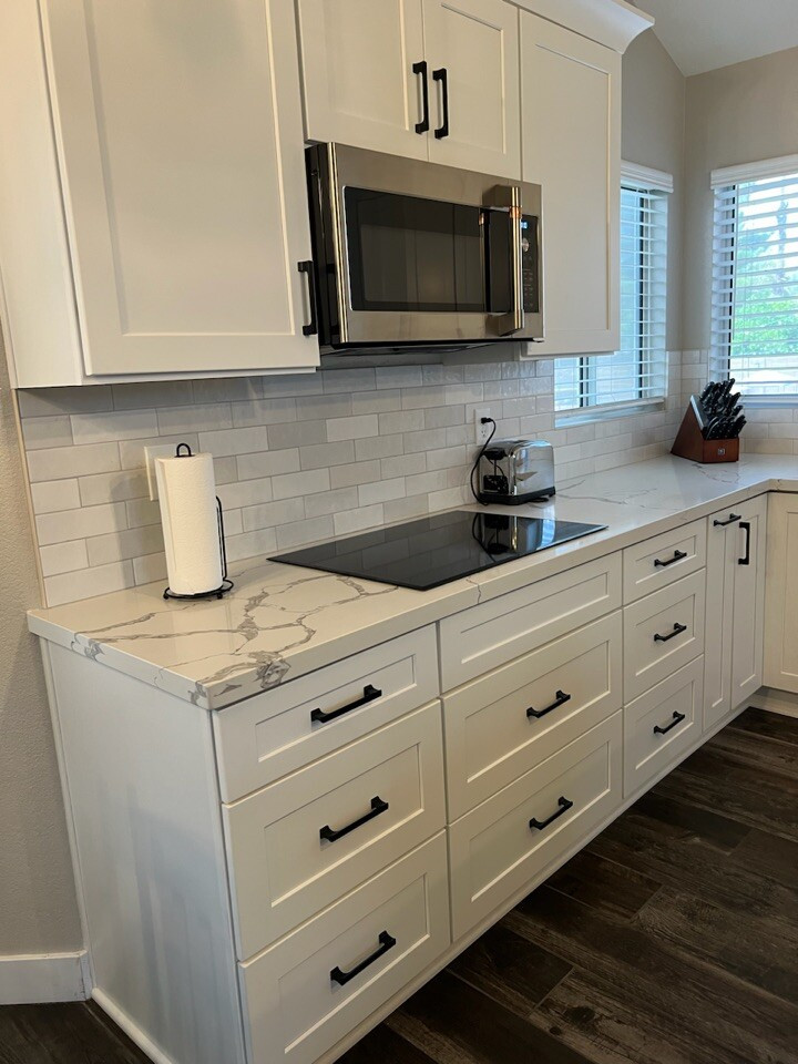 Inspiration for a large traditional l-shaped open plan kitchen in Phoenix with an undermount sink, shaker cabinets, white cabinets, quartzite benchtops, white splashback, ceramic splashback, stainless steel appliances, with island and white benchtop.