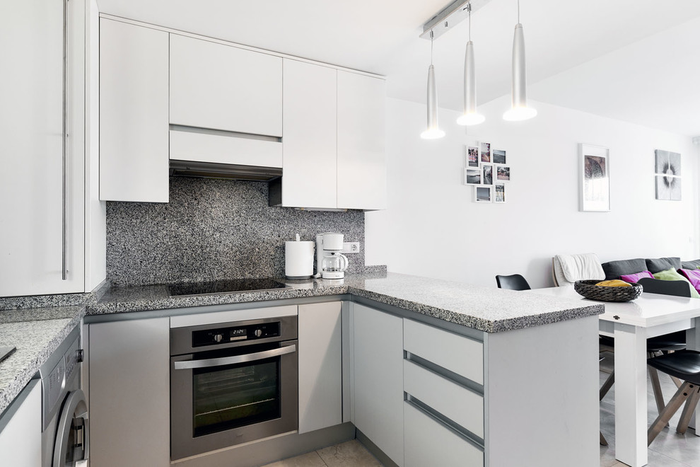 Small scandinavian u-shaped eat-in kitchen in Other with flat-panel cabinets, white cabinets, granite benchtops, multi-coloured splashback and a peninsula.