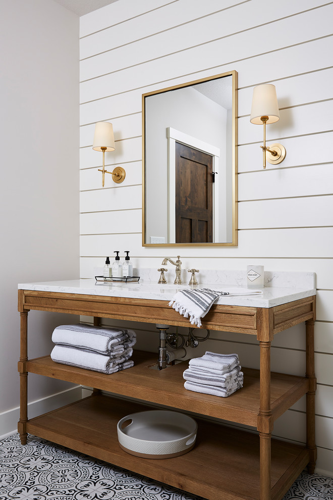 Mid-sized country 3/4 bathroom in Minneapolis with furniture-like cabinets, light wood cabinets, an alcove shower, a two-piece toilet, yellow tile, porcelain tile, white walls, cement tiles, an undermount sink, marble benchtops, white floor, a hinged shower door and white benchtops.