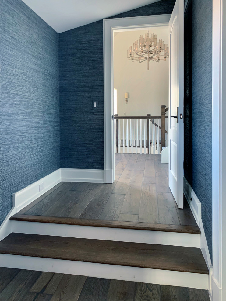 Exemple d'un couloir tendance avec un mur bleu, un sol en bois brun, un sol marron et du papier peint.