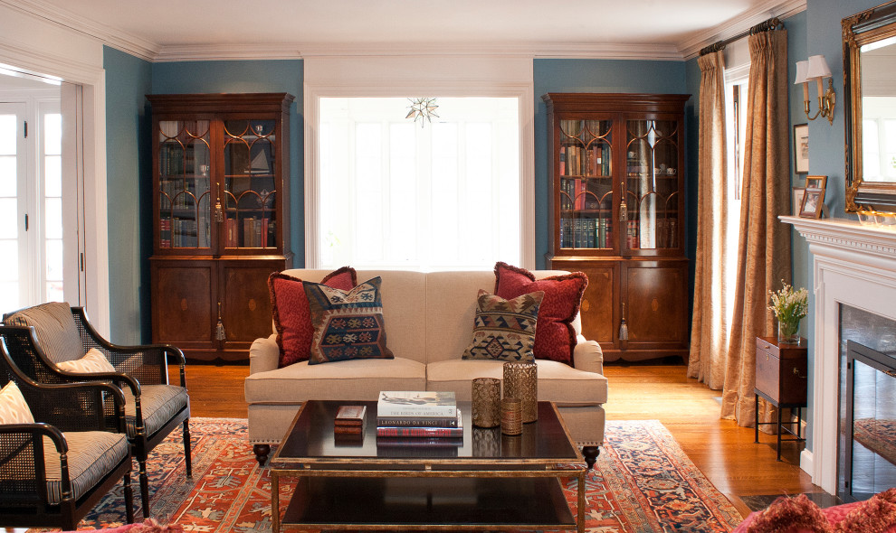Источник вдохновения для домашнего уюта: большая парадная, изолированная гостиная комната в стиле неоклассика (современная классика) с синими стенами, паркетным полом среднего тона, стандартным камином, фасадом камина из камня и коричневым полом без телевизора