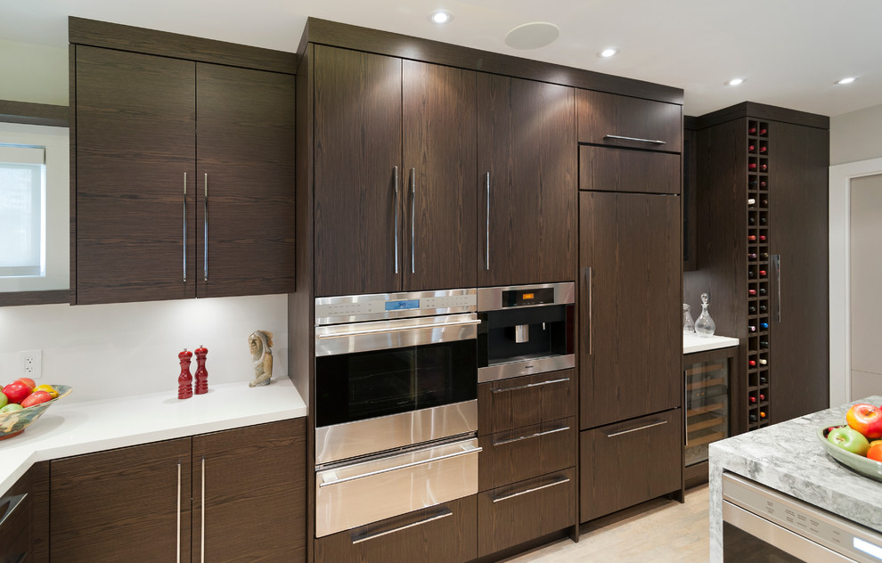Contemporary u-shaped eat-in kitchen in Vancouver with an undermount sink, flat-panel cabinets and dark wood cabinets.