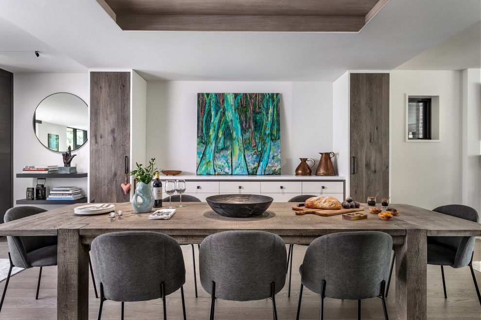 Idée de décoration pour une salle à manger ouverte sur le salon urbaine de taille moyenne avec un mur blanc, un sol en bois brun, un sol gris et un plafond à caissons.