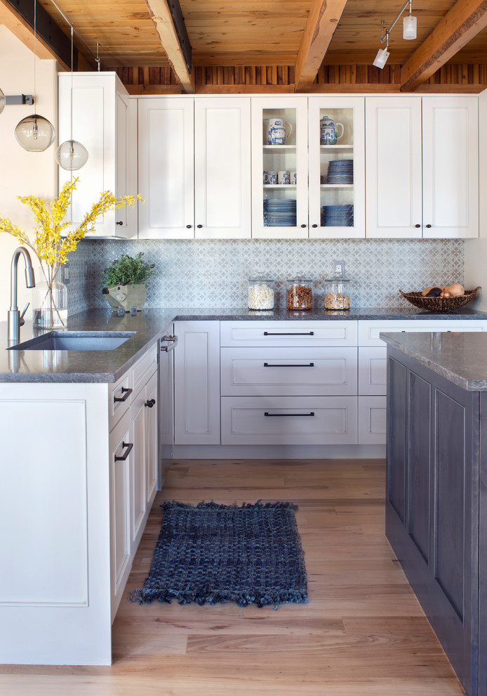 Large transitional l-shaped light wood floor and beige floor open concept kitchen photo in Denver with an undermount sink, shaker cabinets, white cabinets, quartzite countertops, gray backsplash, stainless steel appliances, an island and gray countertops