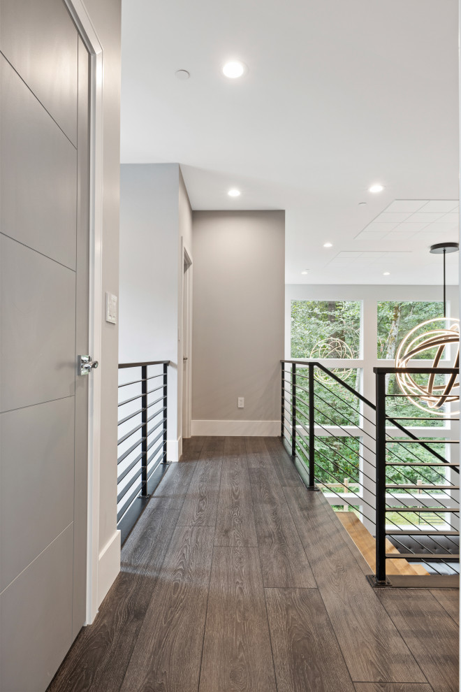 Idées déco pour un couloir moderne de taille moyenne avec un mur gris, un sol en vinyl, un sol gris et un plafond voûté.