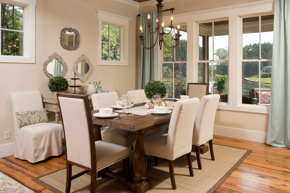 This is an example of a country dining room in Charleston with beige walls and medium hardwood floors.