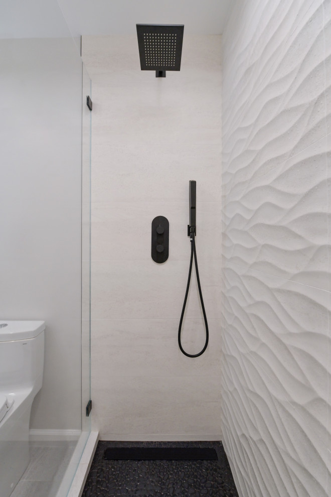 This is an example of a medium sized contemporary shower room bathroom in Austin with an alcove shower, a one-piece toilet, white tiles, ceramic tiles, white walls, pebble tile flooring, black floors, a hinged door and a wall niche.