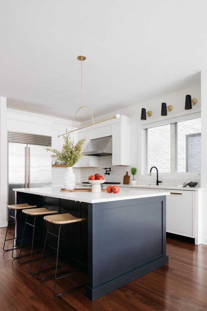 Moderne Küche mit Küchenrückwand in Weiß, Rückwand aus Metrofliesen, Küchengeräten aus Edelstahl, dunklem Holzboden und Kücheninsel in Chicago