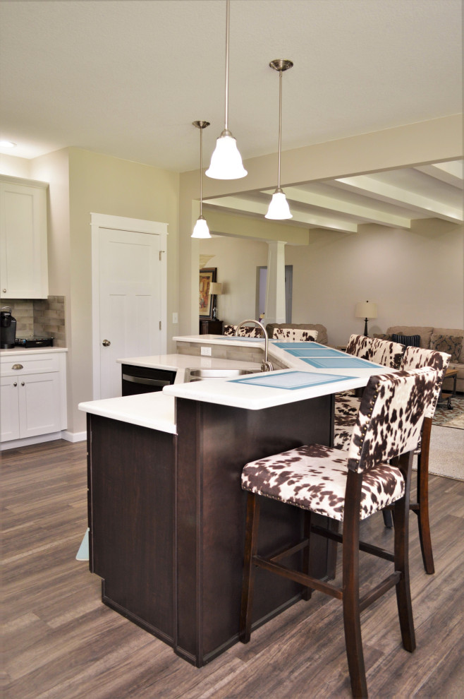 Open concept kitchen - mid-sized transitional single-wall open concept kitchen idea with a drop-in sink, shaker cabinets, white cabinets, quartzite countertops, beige backsplash, stainless steel appliances, an island and white countertops