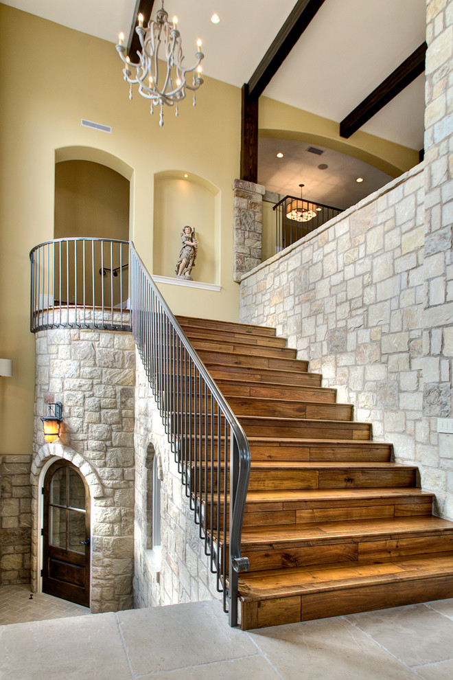 This is an example of a mid-sized mediterranean wood straight staircase in Austin with wood risers.