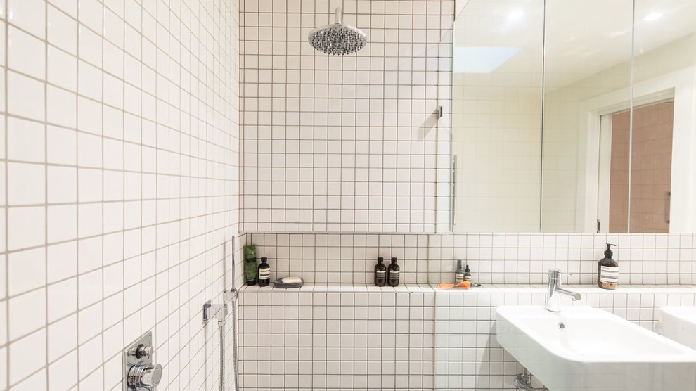 Design ideas for a mid-sized transitional master bathroom in Melbourne with white cabinets, an alcove shower, a two-piece toilet, white tile, ceramic tile, white walls, cement tiles, a wall-mount sink, tile benchtops, grey floor, an open shower and white benchtops.