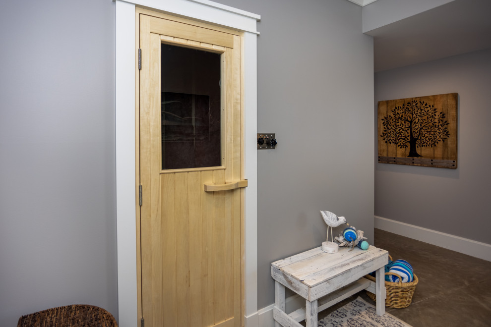 Ejemplo de sótano con puerta clásico extra grande con paredes grises, suelo de cemento y suelo beige