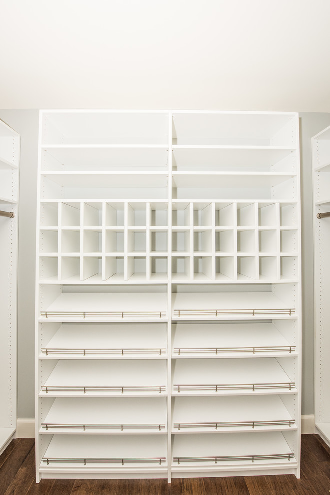 This is an example of a large modern gender-neutral walk-in wardrobe in Nashville with white cabinets, carpet and white floor.