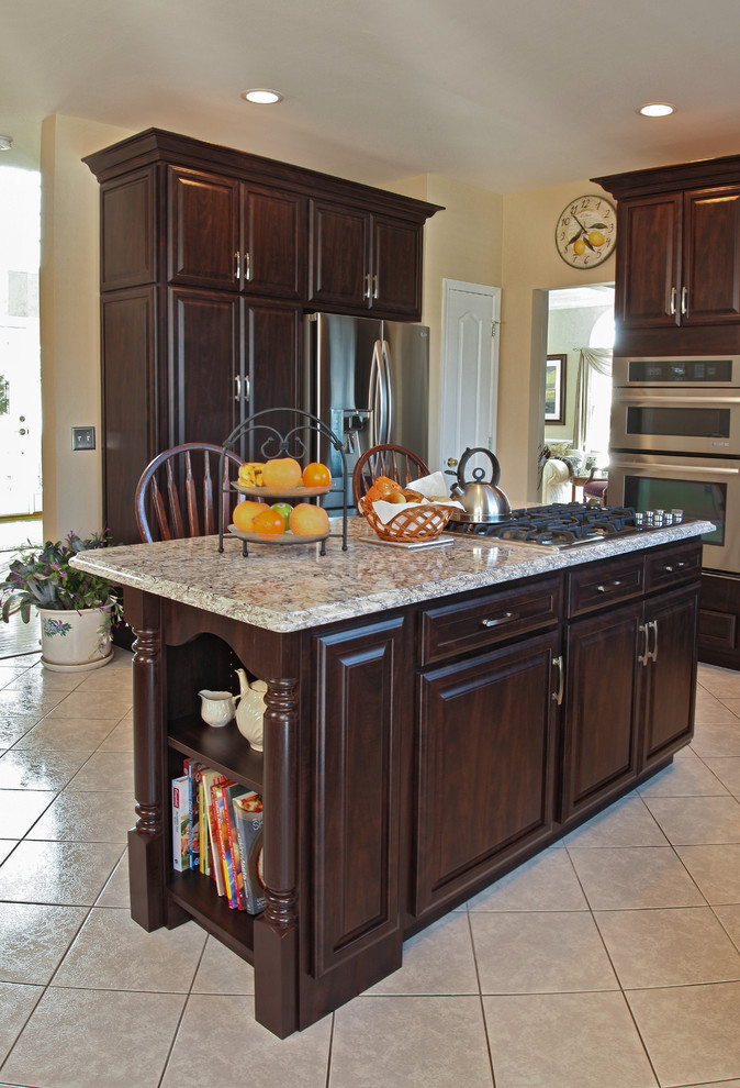 Large transitional l-shaped ceramic tile eat-in kitchen photo in Boston with a double-bowl sink, raised-panel cabinets, quartzite countertops, white backsplash, ceramic backsplash, stainless steel appliances and an island