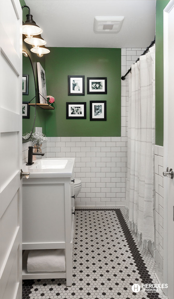 Photo of a small eclectic 3/4 bathroom in St Louis with flat-panel cabinets, white cabinets, an alcove tub, a shower/bathtub combo, a wall-mount toilet, white tile, ceramic tile, green walls, porcelain floors, an integrated sink, white floor, a shower curtain, white benchtops, a single vanity, a freestanding vanity and decorative wall panelling.