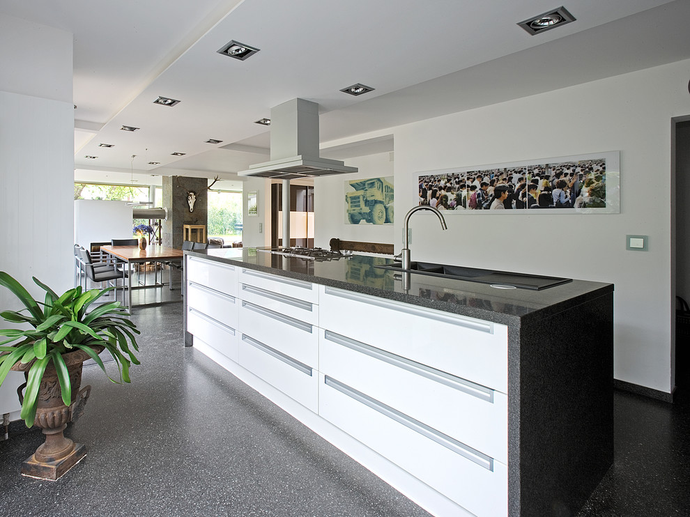 Large contemporary open plan kitchen in Stuttgart with a drop-in sink, flat-panel cabinets, white cabinets and with island.