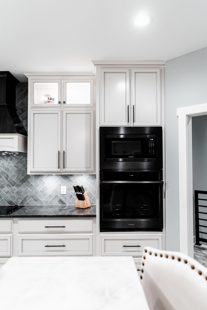 Inspiration for a huge transitional l-shaped laminate floor, gray floor and tray ceiling open concept kitchen remodel with an undermount sink, flat-panel cabinets, white cabinets, quartz countertops, gray backsplash, ceramic backsplash, black appliances and an island