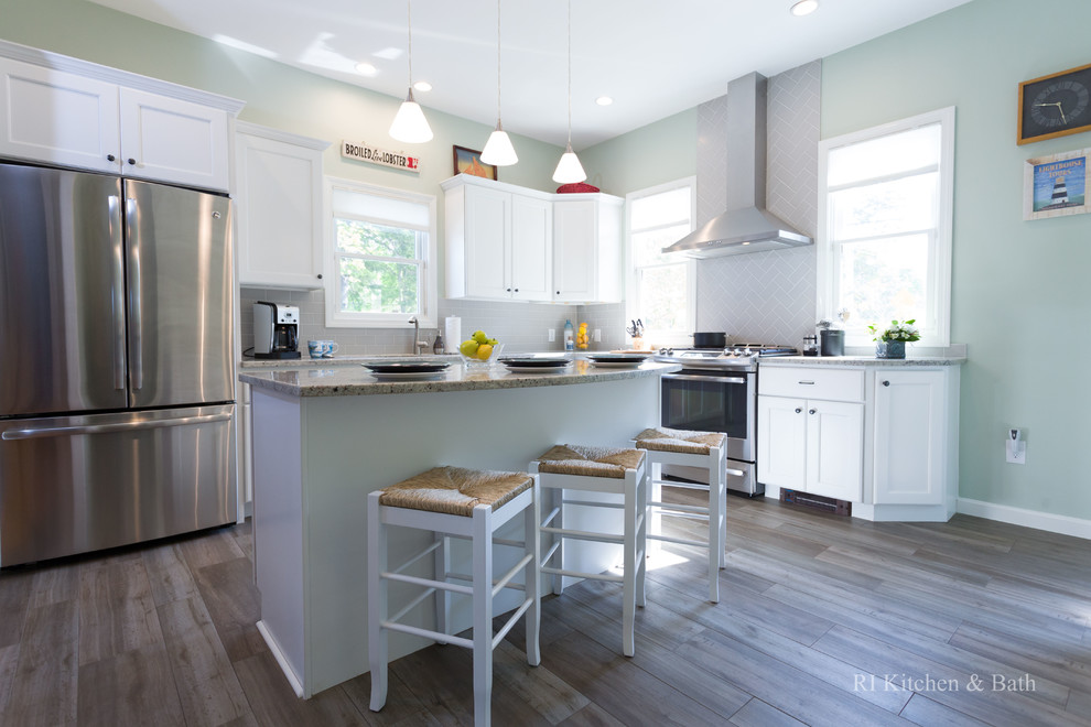 Large transitional l-shaped porcelain tile eat-in kitchen photo in Providence with an undermount sink, recessed-panel cabinets, white cabinets, granite countertops, gray backsplash, ceramic backsplash, stainless steel appliances, green walls and an island