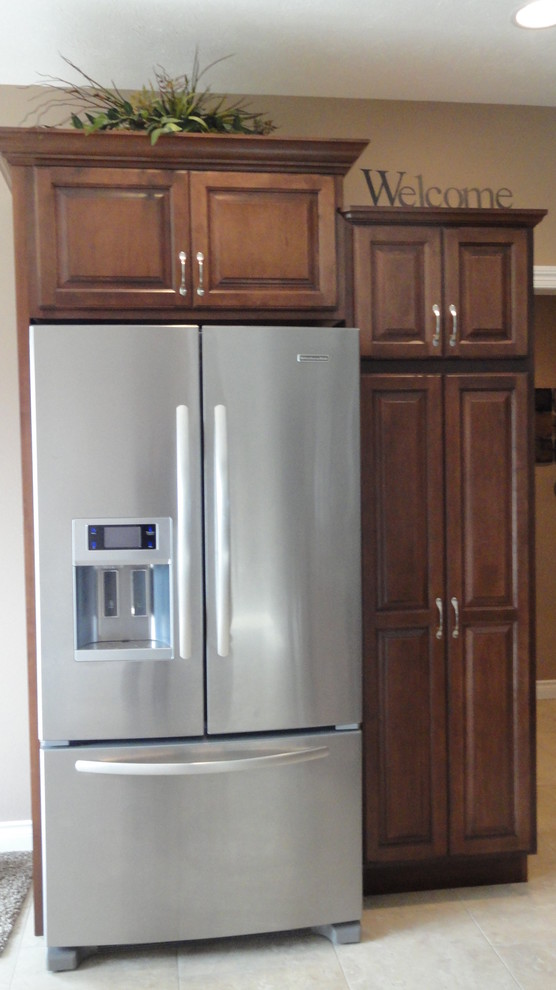 Open concept kitchen - mid-sized l-shaped open concept kitchen idea with an undermount sink, raised-panel cabinets, dark wood cabinets, laminate countertops, stainless steel appliances, beige walls and an island
