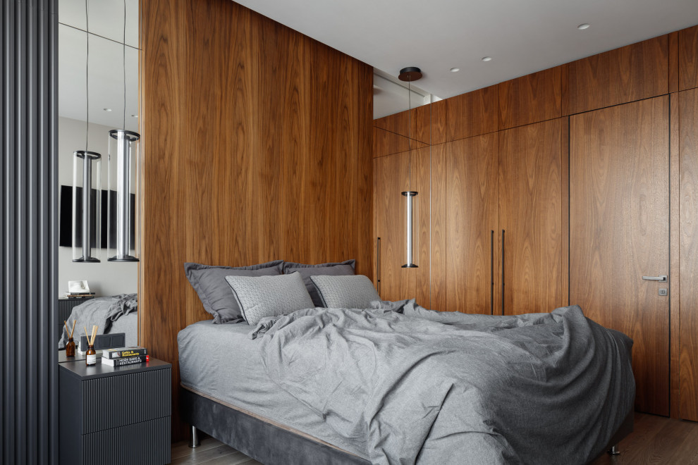 Ejemplo de dormitorio principal y blanco y madera actual pequeño con paredes blancas, suelo de madera en tonos medios, suelo marrón, bandeja y boiserie