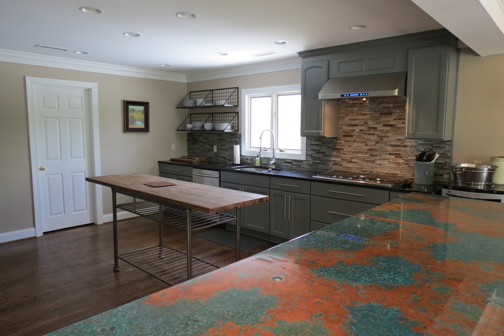 Inspiration for a large transitional dark wood floor and brown floor kitchen remodel with a double-bowl sink, recessed-panel cabinets, gray cabinets, granite countertops, multicolored backsplash, stone tile backsplash, stainless steel appliances and two islands