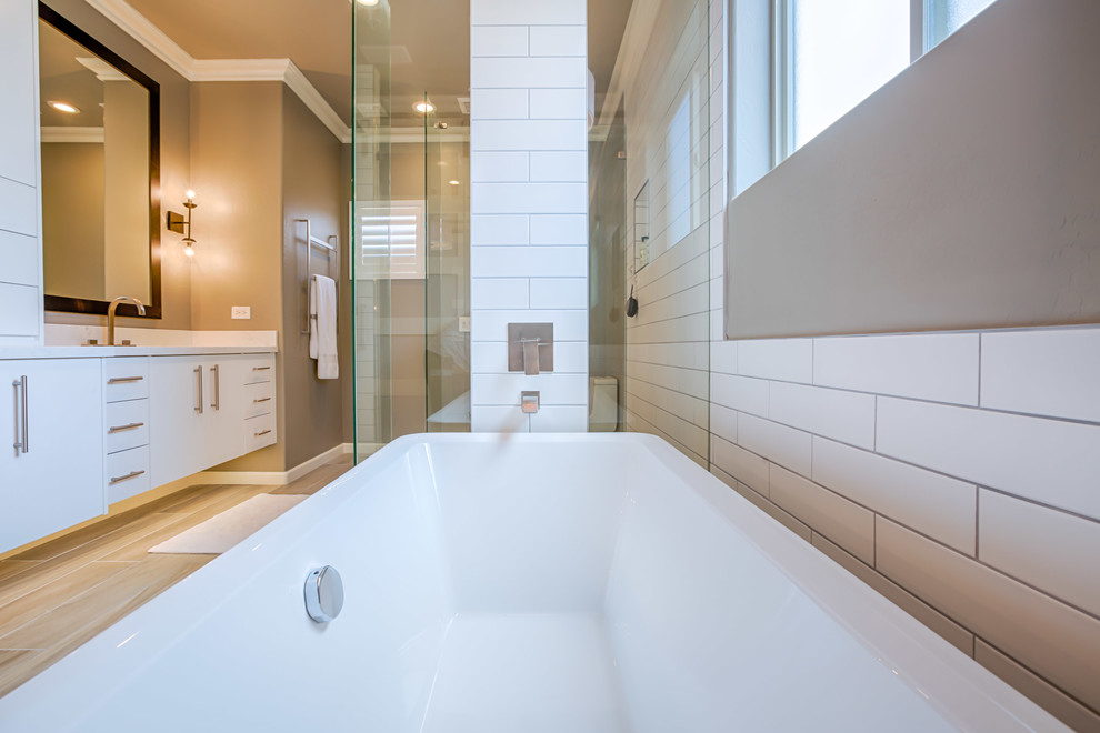Inspiration for a large modern master bathroom in Phoenix with flat-panel cabinets, white cabinets, a freestanding tub, an open shower, a one-piece toilet, white tile, subway tile, grey walls, porcelain floors, an undermount sink, quartzite benchtops, grey floor and an open shower.