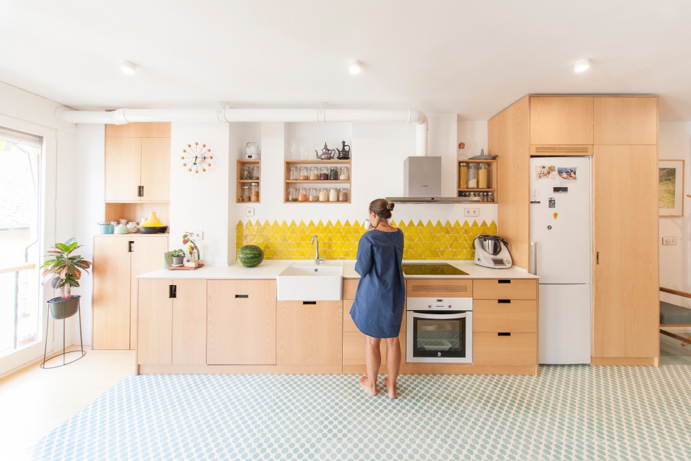 Design ideas for a mid-sized scandinavian single-wall eat-in kitchen in Madrid with a single-bowl sink, light wood cabinets, yellow splashback, ceramic splashback, white appliances, cement tiles, no island, blue floor and white benchtop.