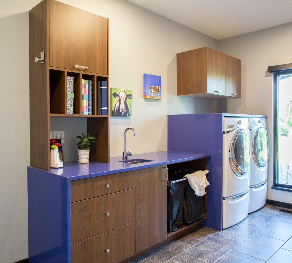 Idee per una sala lavanderia minimalista di medie dimensioni con lavello sottopiano, ante lisce, ante in legno scuro, top in quarzo composito, lavatrice e asciugatrice affiancate, top blu, pareti beige, pavimento in ardesia e pavimento marrone